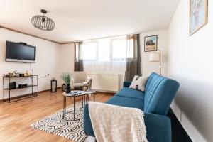 a living room with a blue couch and a tv at Apartman Suman in Vukovar