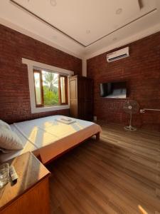 a bedroom with a bed and a brick wall at vuyen villa in Phú Quốc