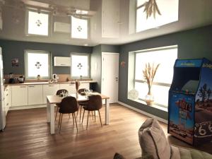 a kitchen and dining room with a table and chairs at Appartement cosy ambiance Palm Spring dans résidence avec piscine 4 pers 2 chambres in Neuf-Mesnil