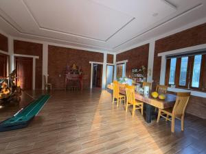a living room with a wooden table and chairs at vuyen villa in Phú Quốc +4 photos