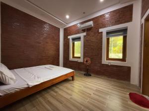 a bedroom with a bed and a brick wall at vuyen villa in Phú Quốc