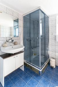 a bathroom with a glass shower and a sink at Apartman Suman in Vukovar