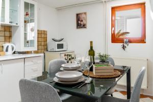 a dining room with a table and chairs and a kitchen at Apartman Suman in Vukovar +43 photos