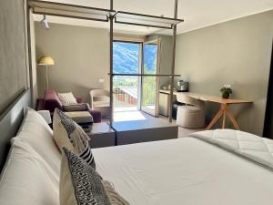 ein Schlafzimmer mit Bett, Schreibtisch und Fenster in der Unterkunft Ca' di Av in Berbenno di Valtellina