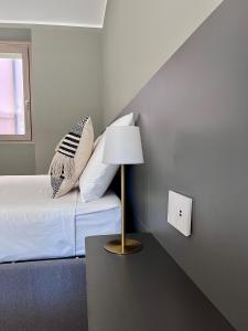 ein Schlafzimmer mit einem Bett und einer Lampe auf einem Tisch in der Unterkunft Ca' di Av in Berbenno di Valtellina