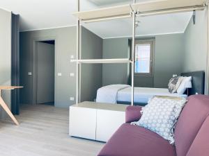 ein Schlafzimmer mit einem Etagenbett und einem lila Sofa in der Unterkunft Ca' di Av in Berbenno di Valtellina