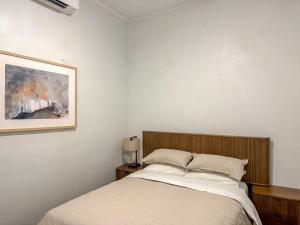 a bedroom with a bed and a painting on the wall at Saltbush Cottage in Broken Hill