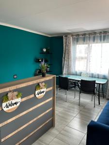 a dining room with a table and a blue wall at The Arrose Guest House in Kwamhlanga