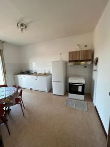 a kitchen with a white refrigerator and a table at Friuli Appartamenti in Cormòns
