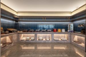 a large kitchen with blue tiles on the wall at Maihao Hotel in Rujiazhuang