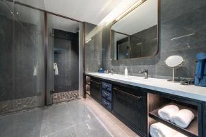 a bathroom with a sink and a mirror at Maihao Hotel in Rujiazhuang +3 photos