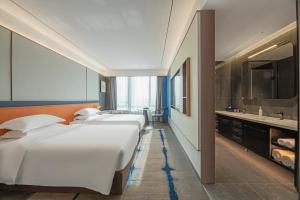 a row of beds in a room with a sink at Maihao Hotel in Rujiazhuang