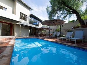 a swimming pool in front of a house at Monte Bello Guesthouse in Windhoek