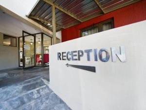 a reception sign in front of a building at Monte Bello Guesthouse in Windhoek