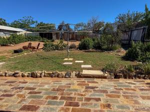 a backyard with a stone walkway and a yard at Saltbush Cottage in Broken Hill