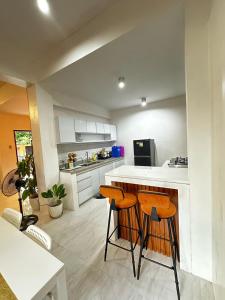 a kitchen with a counter and two stools in it at Qagayon Homestay in Sampong