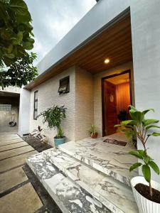 a house with a porch with plants in front of it at Qagayon Homestay in Sampong