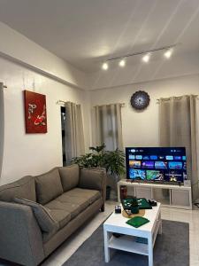 a living room with a couch and a tv at Qagayon Homestay in Sampong