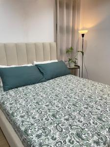 a bedroom with a large bed with blue pillows at Qagayon Homestay in Sampong +16 photos