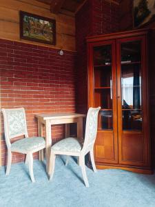 a table and two chairs next to a brick wall at Schronisko Stary Młyn in Zakopane
