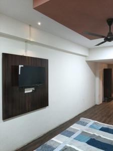 a bedroom with a flat screen tv on a wall at Hotel HV Palace in Bhuj