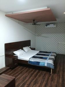 a bedroom with a bed with a wooden floor at Hotel HV Palace in Bhuj +13 photos