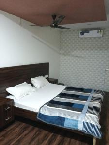 a bedroom with a bed with a blue and white blanket at Hotel HV Palace in Bhuj