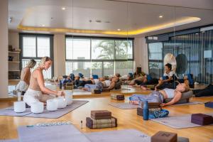 a group of people sitting in a yoga class at HOMA Cherngtalay Phuket in Bang Tao Beach