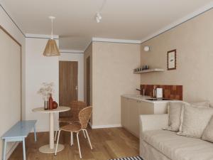 a living room and kitchen with a couch and a table at Złota 34 Karwia in Karwia