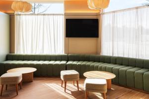 a living room with a green couch and tables at B&B HOTEL Madrid Vallecas Ensanche in Madrid