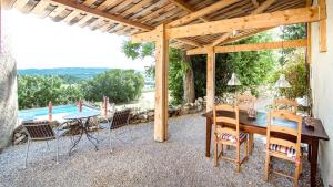 a patio with a table and chairs and a pool at La Petite Grande in Lurs +15 photos