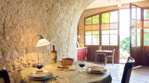 a table with glasses of wine on it in a room at La Petite Grande in Lurs