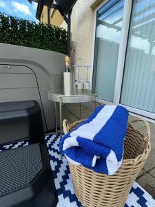 a wicker basket with a blue and white towel on a balcony at North Coast Nook in Portrush