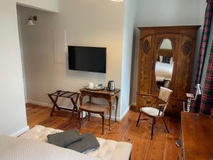 a living room with a television and a table with chairs at B&B Fiddler's Inn in Neuruppin