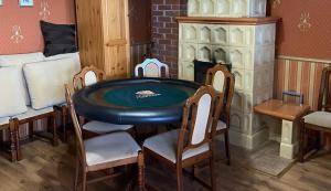 a table and chairs in a room with a fireplace at Kisgeresd Vendégház in Geresdlak