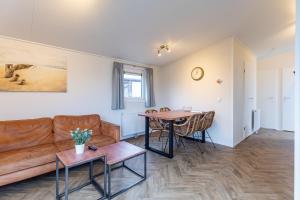 a living room with a couch and a table at Duinhoeve chalet Schelp in Burgh Haamstede