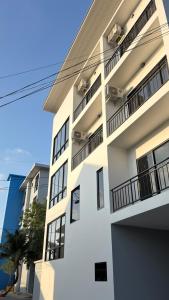 a white building with balconies on the side of it at A House Thalang เอ เฮ้าส์ ถลาง in Thalang