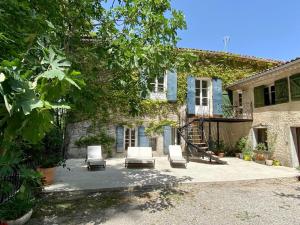 a house with two lounge chairs and a staircase at Domaine Notre Dame des Anges in Lurs