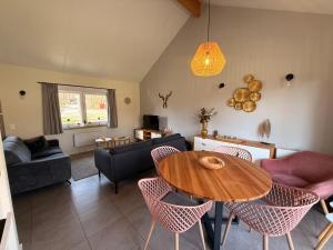 a living room with a wooden table and chairs at Bois de l'Ourthe 202 in Somme-Leuze