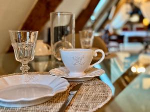 a table with a cup and a plate and glass at Manoir du Val Riant in Saint Malo