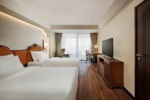 a hotel room with two beds and a television at Bhangeri Durbar Resort in Nagarkot