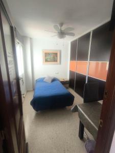 a bedroom with a blue bed and a ceiling fan at Soluna Alcala in Alcalá del Río
