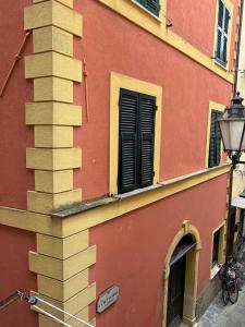 a red and yellow building with a column and window at Central Apartment Monterosso in Monterosso al Mare