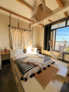 a bedroom with a bed and a large window at Riad Atlas Surf in Tamraght Ouzdar +108 photos