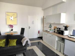 a living room with a couch and a kitchen at Ferienwohnung CityImmo in Gotha +3 photos