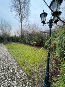 a street light next to a yard with a table at Boshuisje met privétuin bij Kruisbergse bossen Achterhoek in Hummelo
