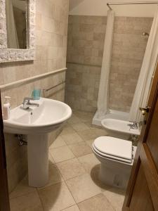 a bathroom with a white sink and a toilet at Pescasseroli center Case del Parco in Pescasseroli