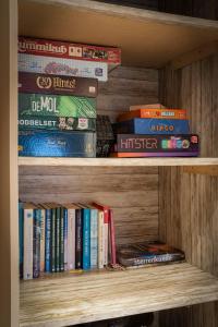 a book shelf filled with lots of books at Boshuisje met privétuin bij Kruisbergse bossen Achterhoek in Hummelo