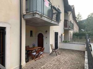 a patio with a table and chairs and a balcony at Pescasseroli center Case del Parco in Pescasseroli