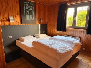 a bedroom with two beds in a wooden room at Gite Ard'zen in Noiseux
